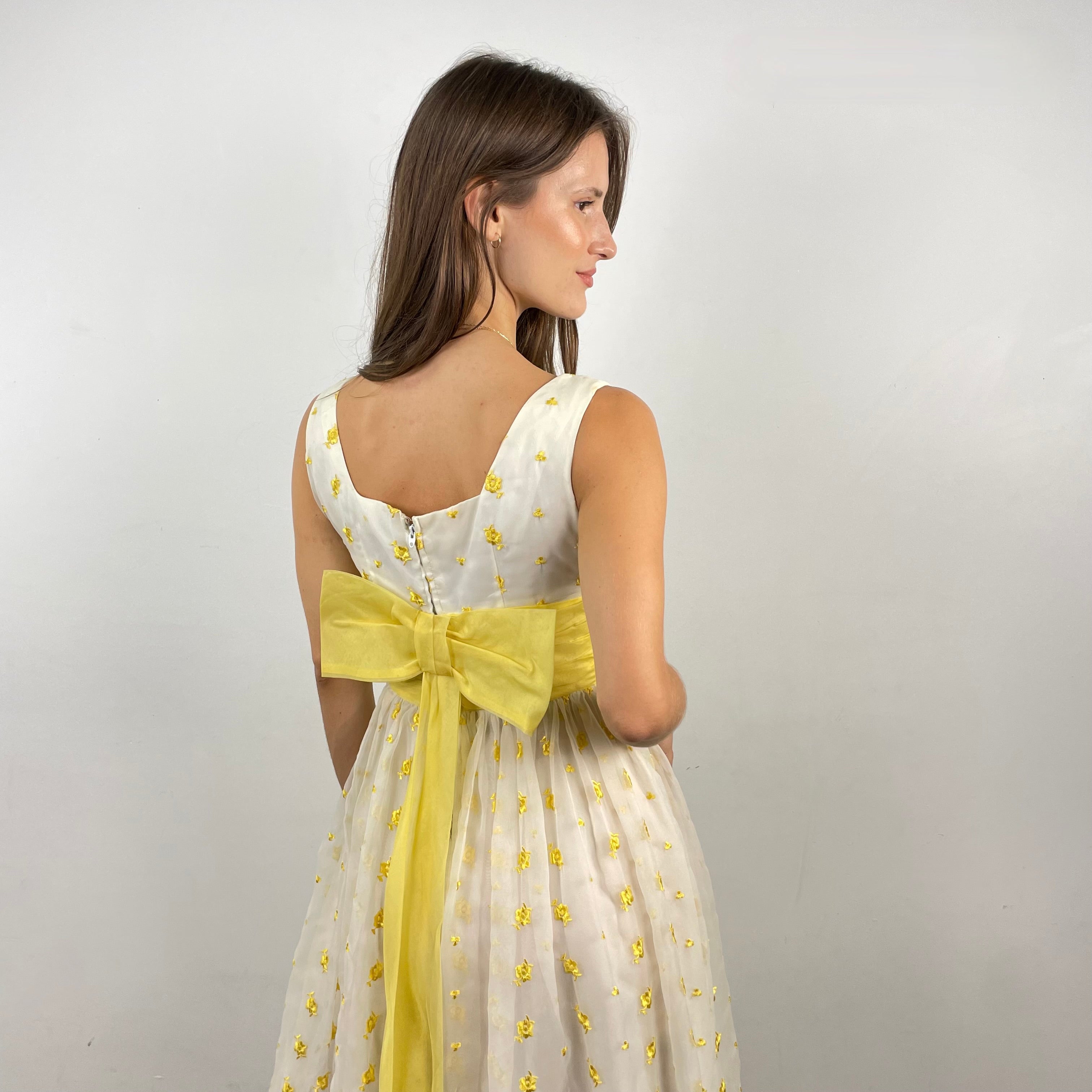 Boheme Vintage 1960s deadstock chiffon gown with yellow floral embroidery, square neckline, and oversized back bow.