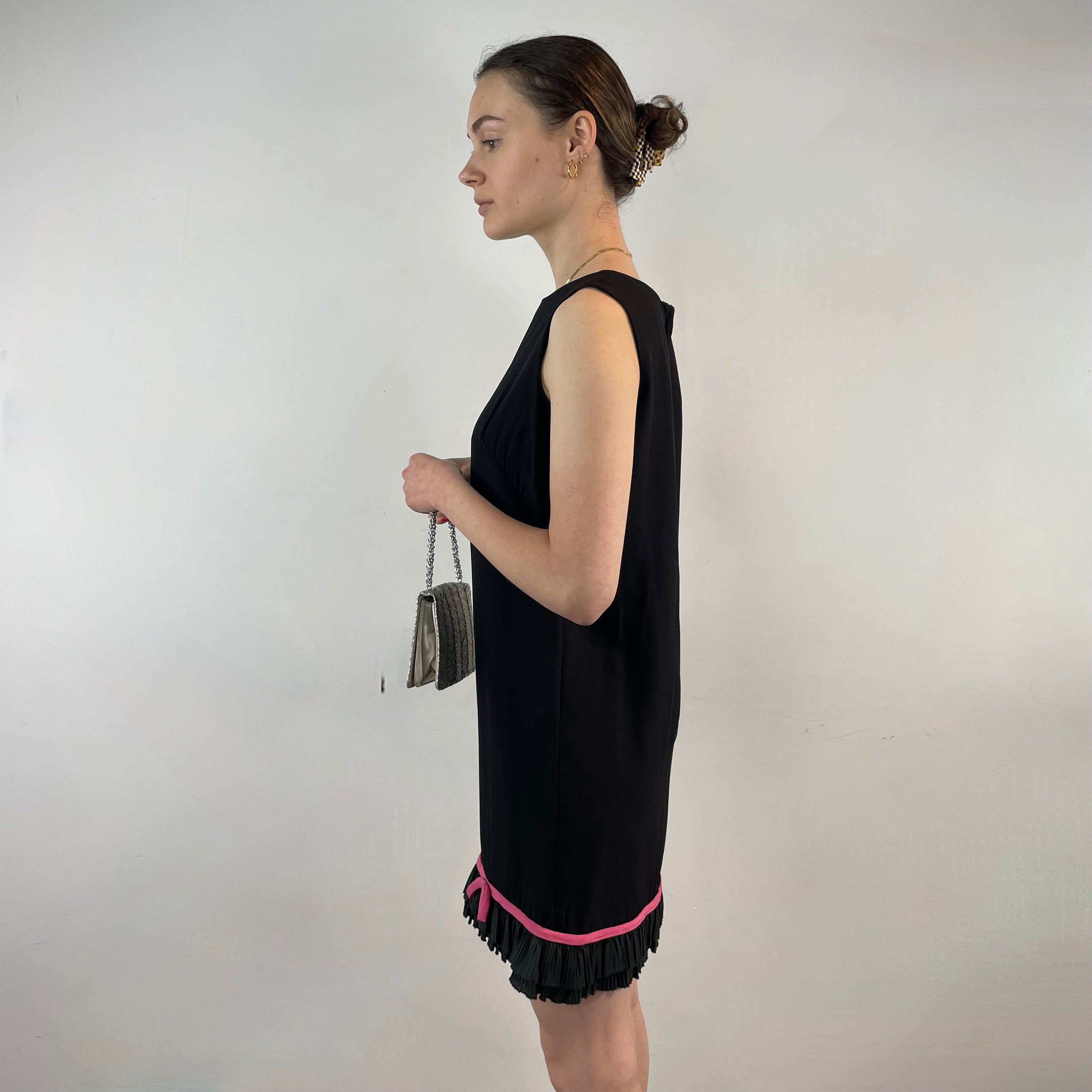 Boheme Vintage 1960s black crepe shift dress with pink ribbon bow hem, sleeveless silhouette, and crew neckline.