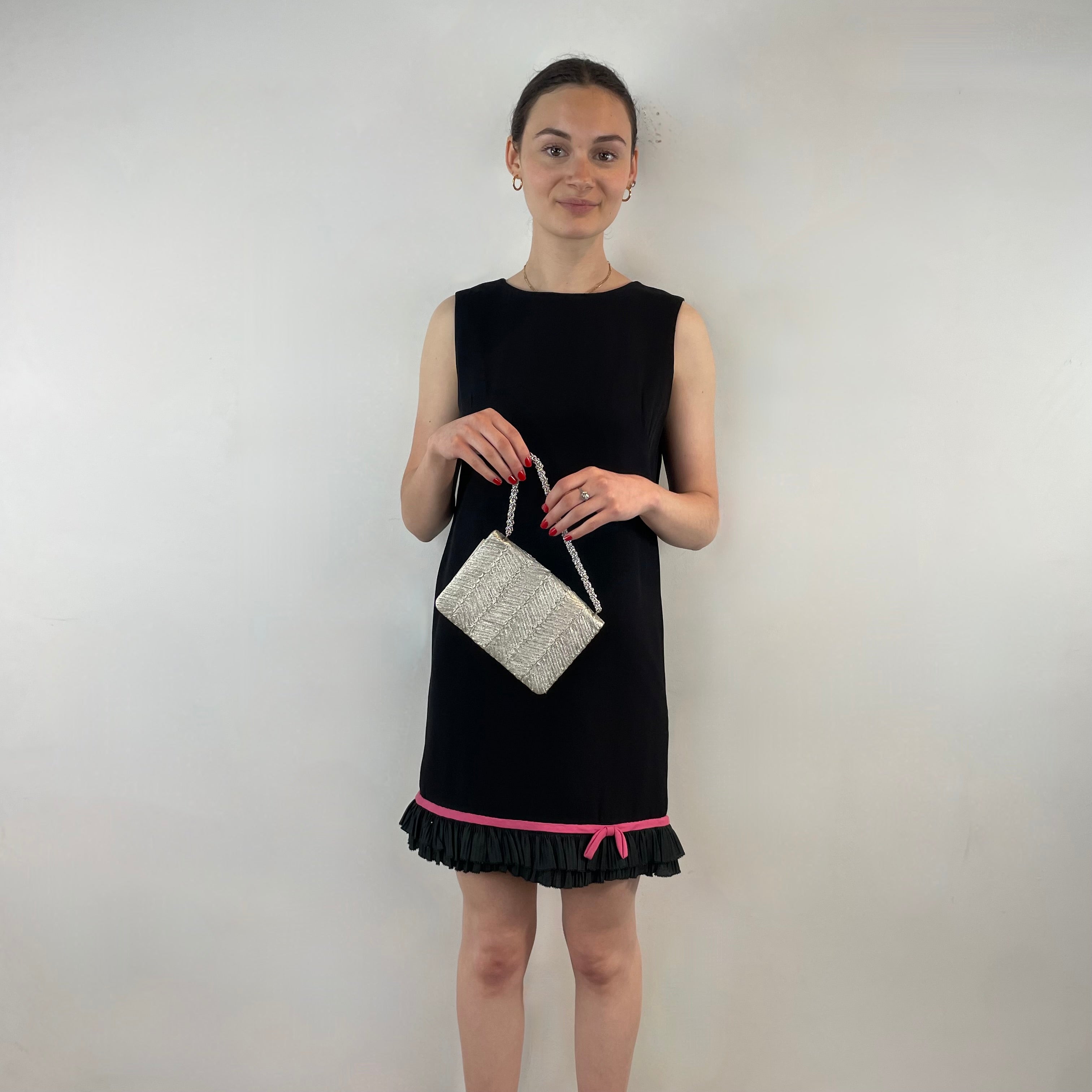 Boheme Vintage 1960s black crepe shift dress with pink ribbon bow hem, sleeveless silhouette, and crew neckline.