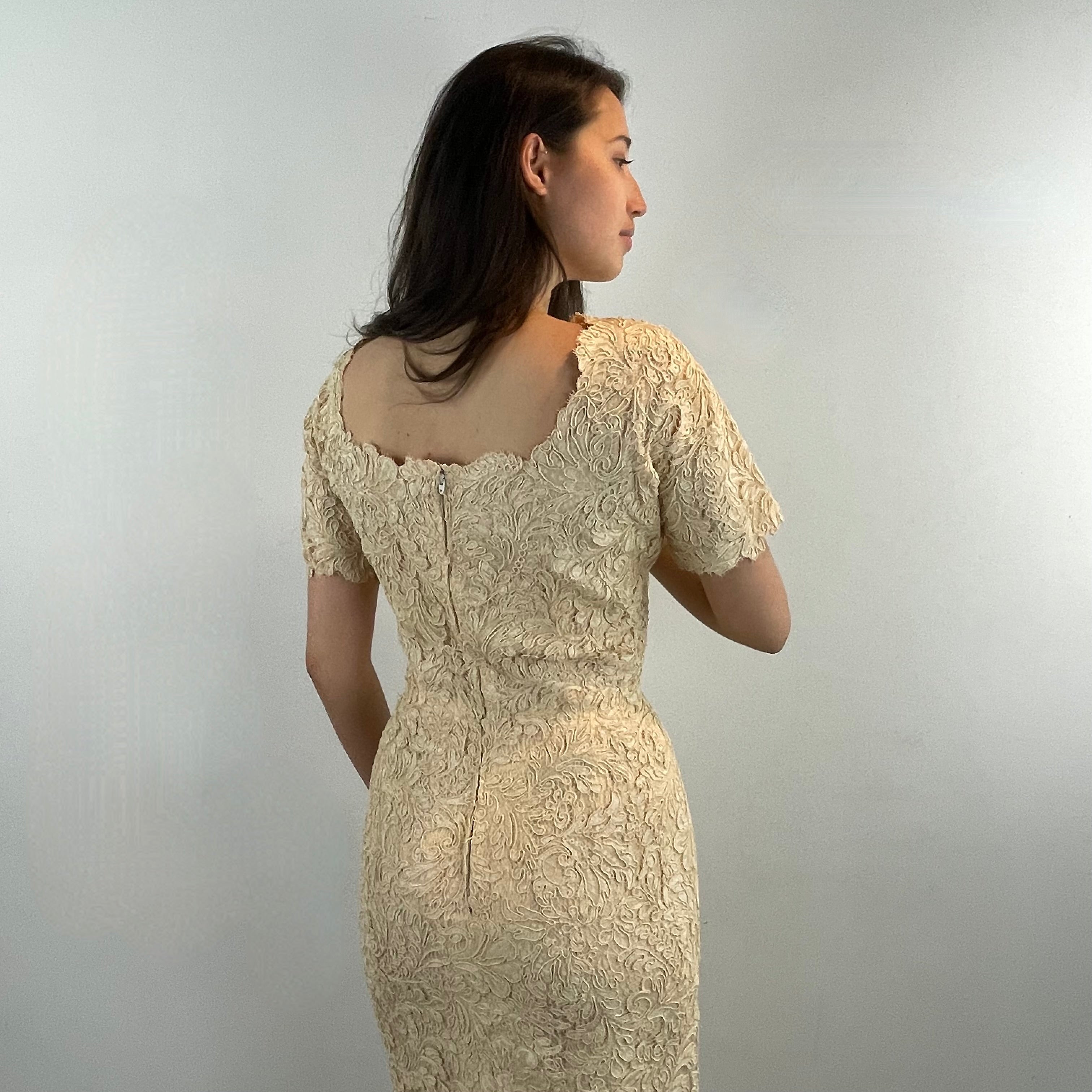 Boheme Vintage 1960s ivory lace dress with scalloped edges, dolman sleeves, and satin bow waist detail.