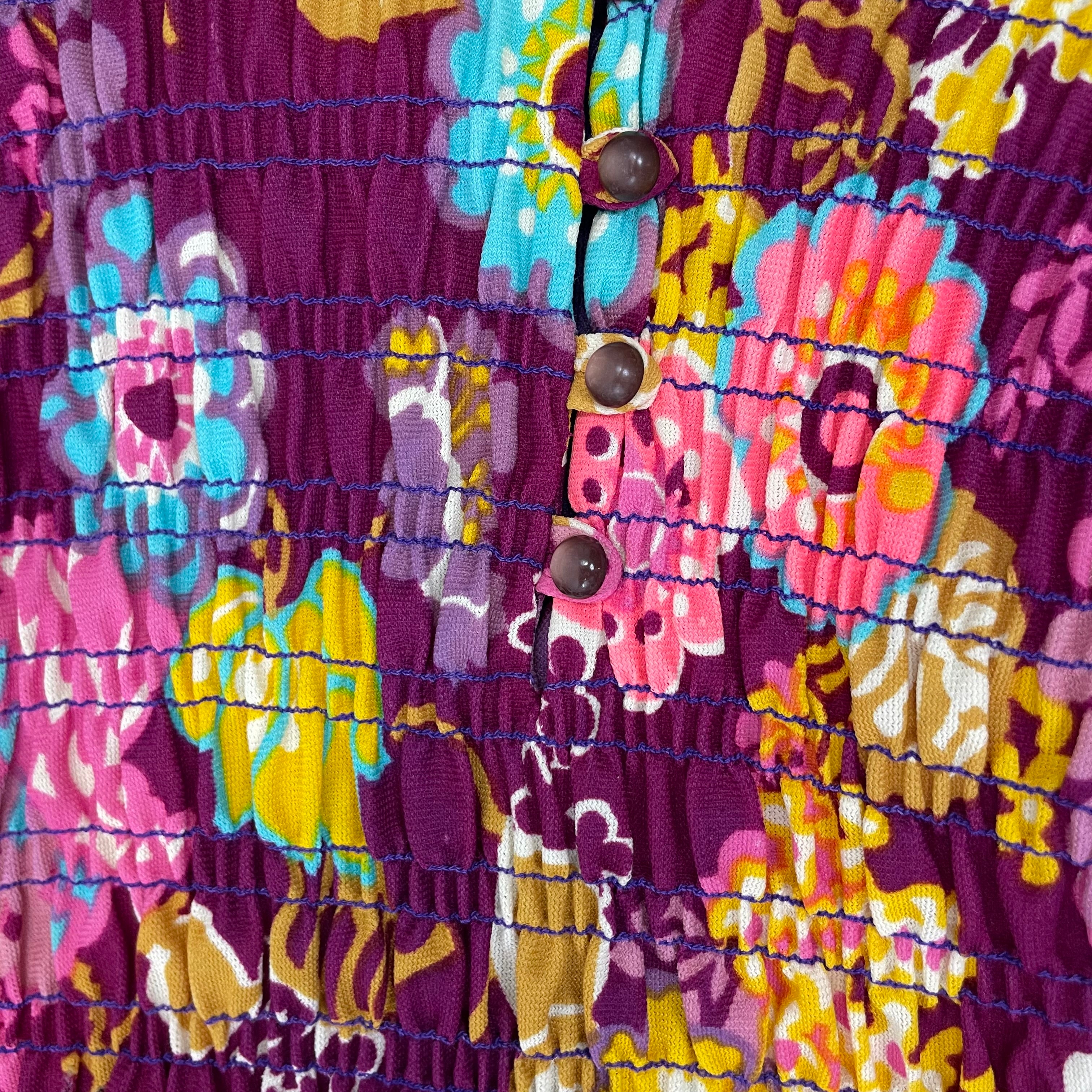Close-up of rushed detailing on bodice of 1970s floral empire waist maxi dress with ruched bodice, high neckline and long ruched sleeves in bold print lightweight fabric – Boheme Vintage Montreal https://bohemevintage.com