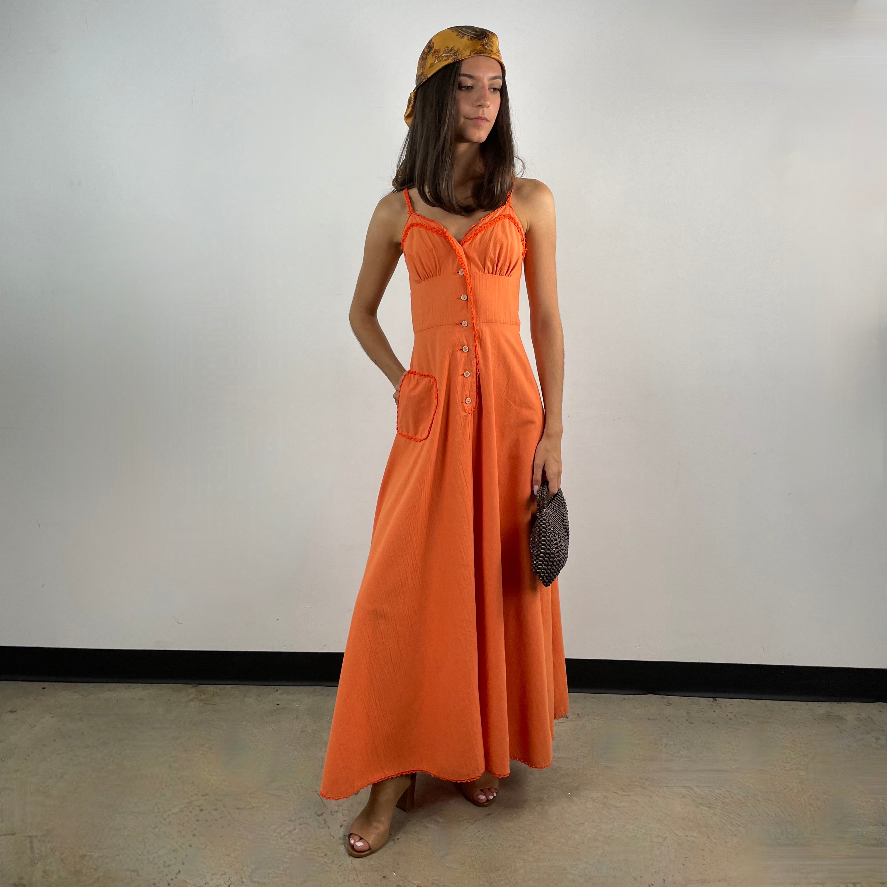 Boheme Vintage 1970s orange cotton empire waist maxi dress with crochet trim, front buttons, flared skirt, and patch pocket.