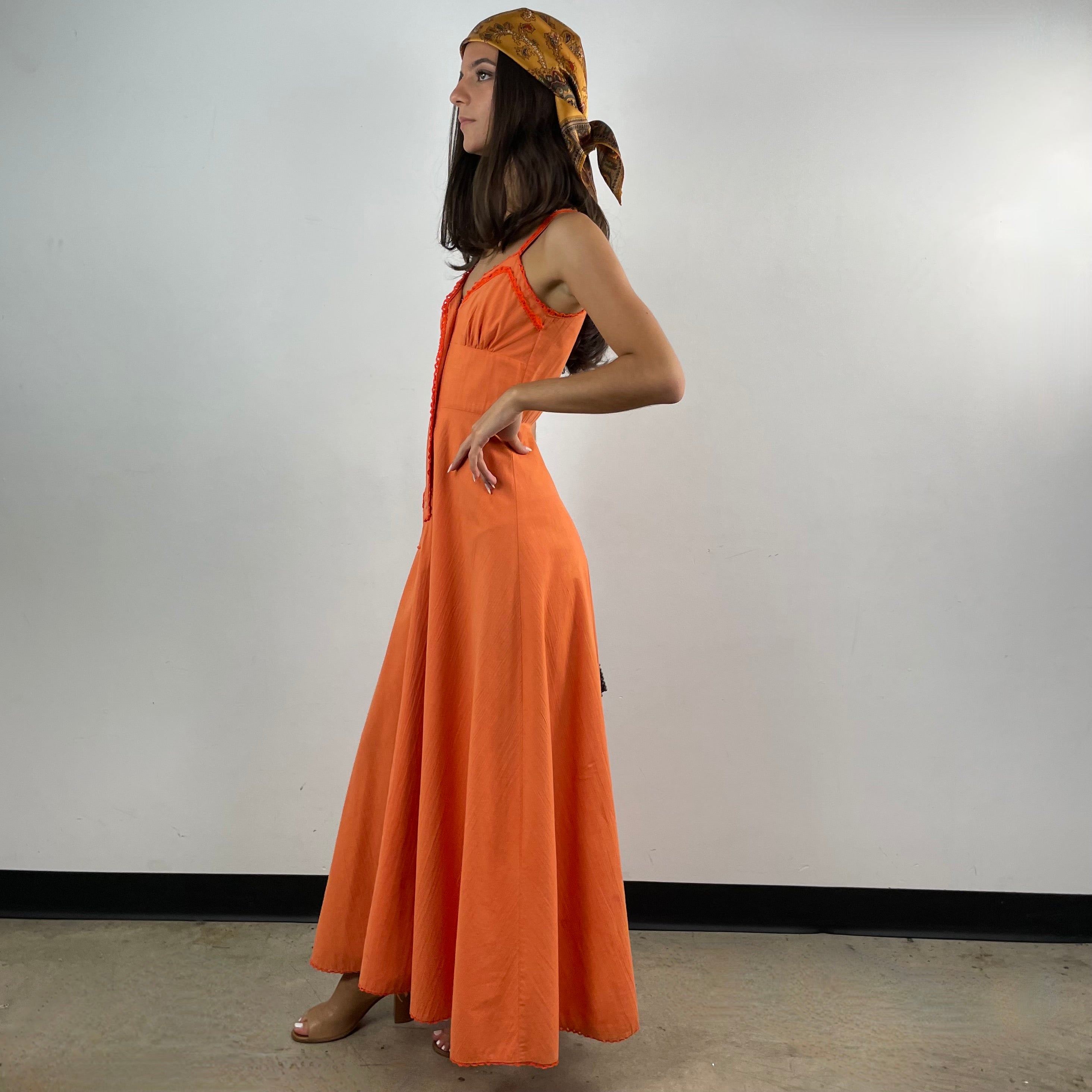 Boheme Vintage 1970s orange cotton empire waist maxi dress with crochet trim, front buttons, flared skirt, and patch pocket.