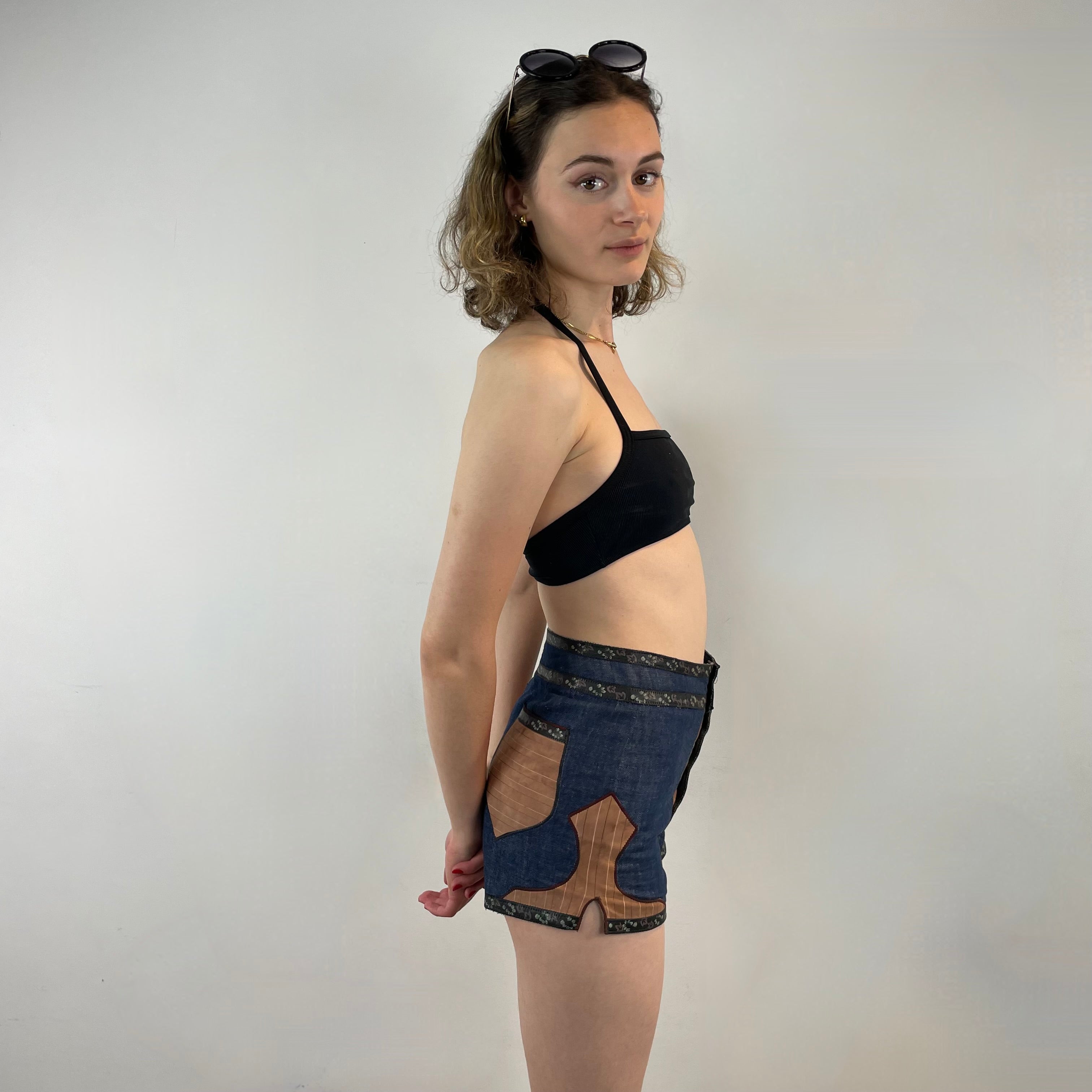 Boheme Vintage 1970s Roberto Cavalli denim and leather hot pants shorts with flower snap closures and leather appliqué details.