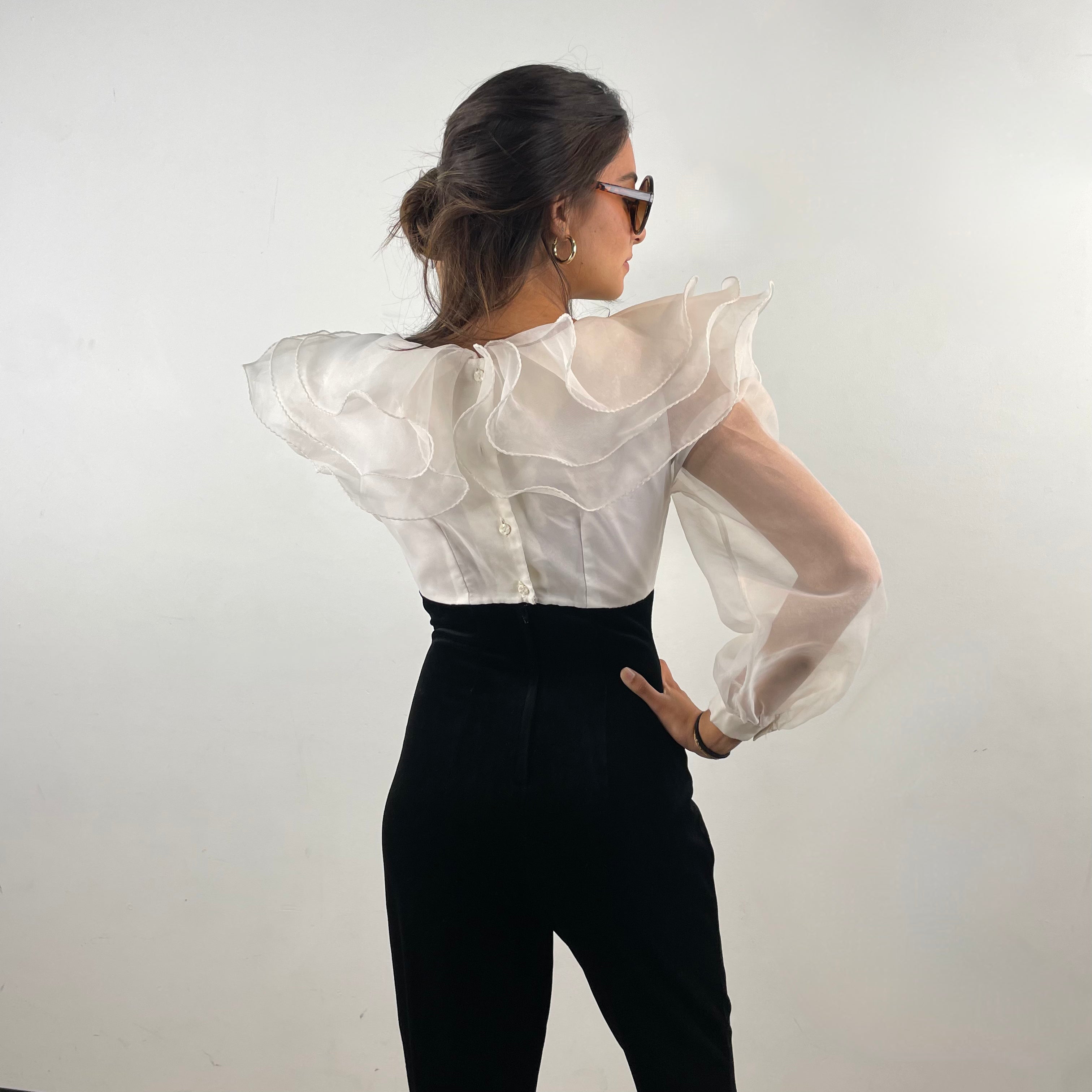 Back view of 1980s Ruffle Collar Stirrup Jumpsuit
Size Small
Sold at bohemevintage.com Montréal