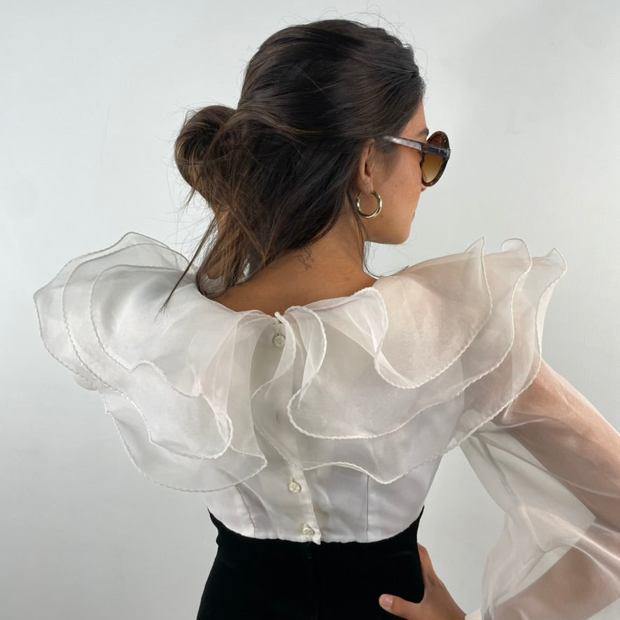 Close up back view of 1980s Ruffle Collar Stirrup Jumpsuit
Size Small
Sold at bohemevintage.com Montréal