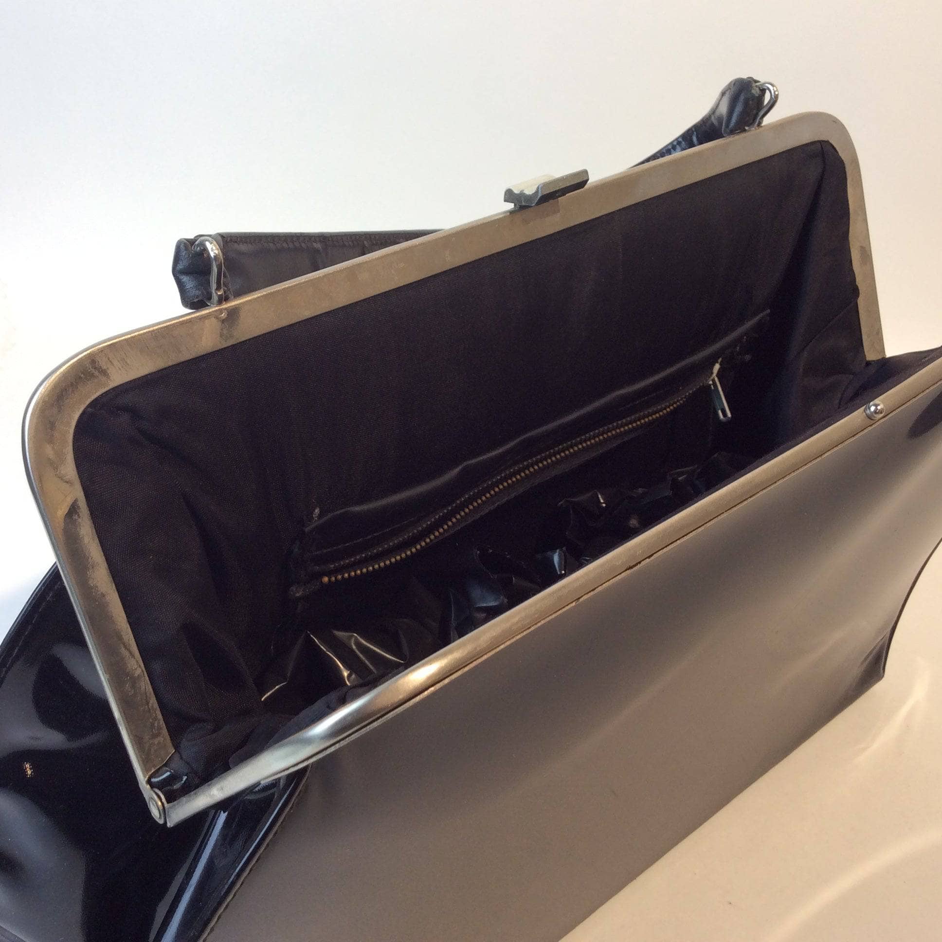 Inside view of 1950s Black Faux Patent Leather Oversized Frame Bag. Sold by bohemevintage.com