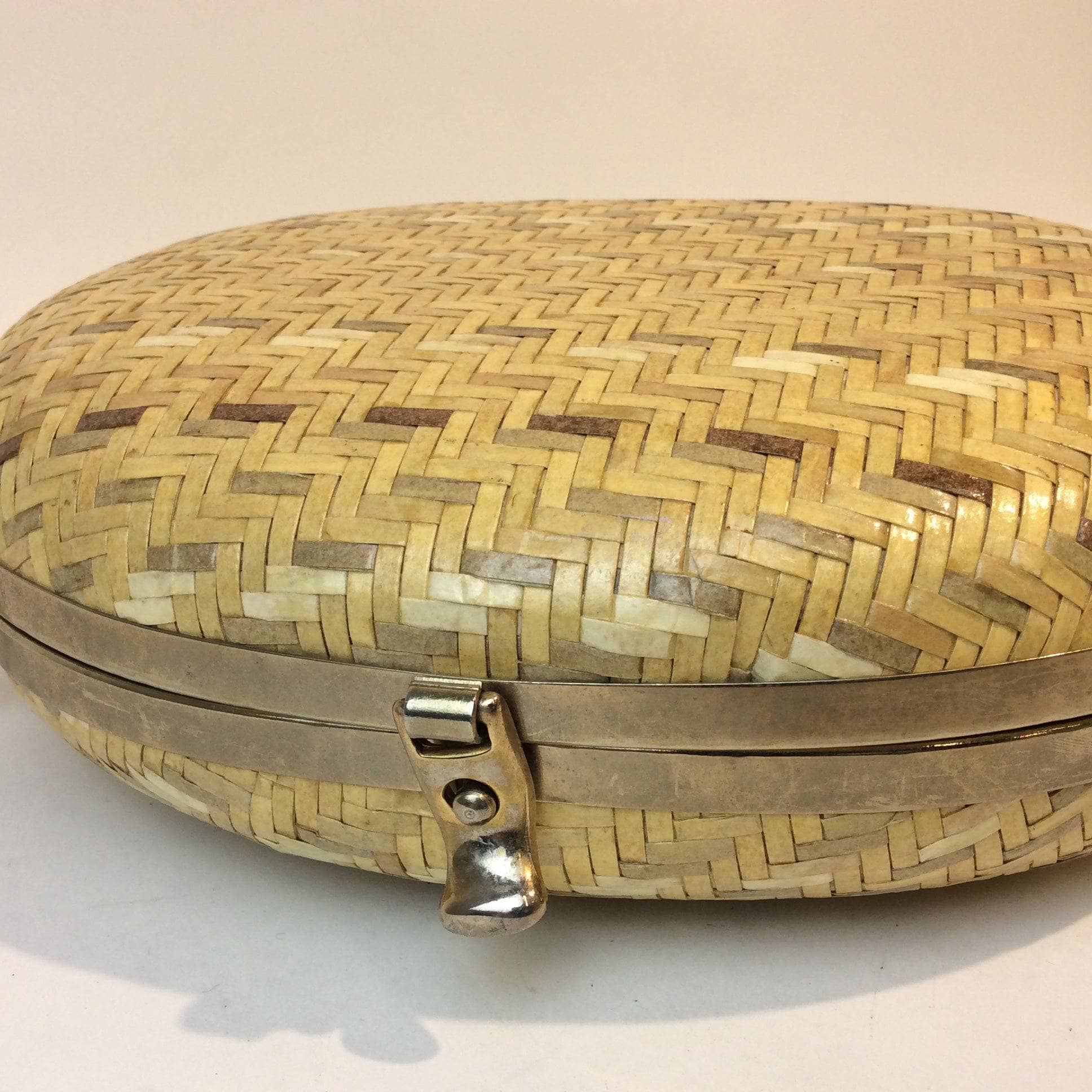 Close-up view of clasp of 1980s-1990s Oval Shape Hard Shell Woven Straw Shoulder Bag sold by bohemevintage.com Montreal