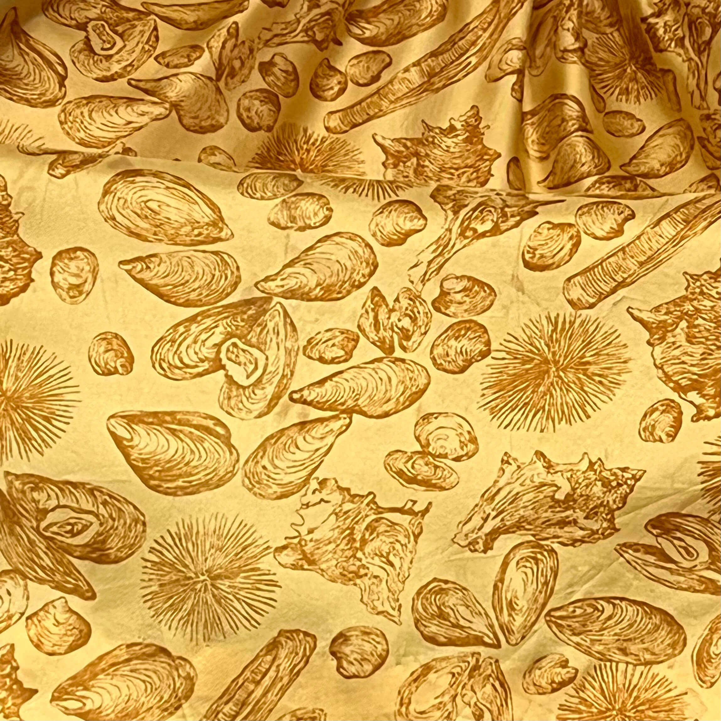 Close-up of fabric of Boheme Vintage 1950s L’aiglon seashell print gold acetate dress with pleated skirt and fitted bodice.
