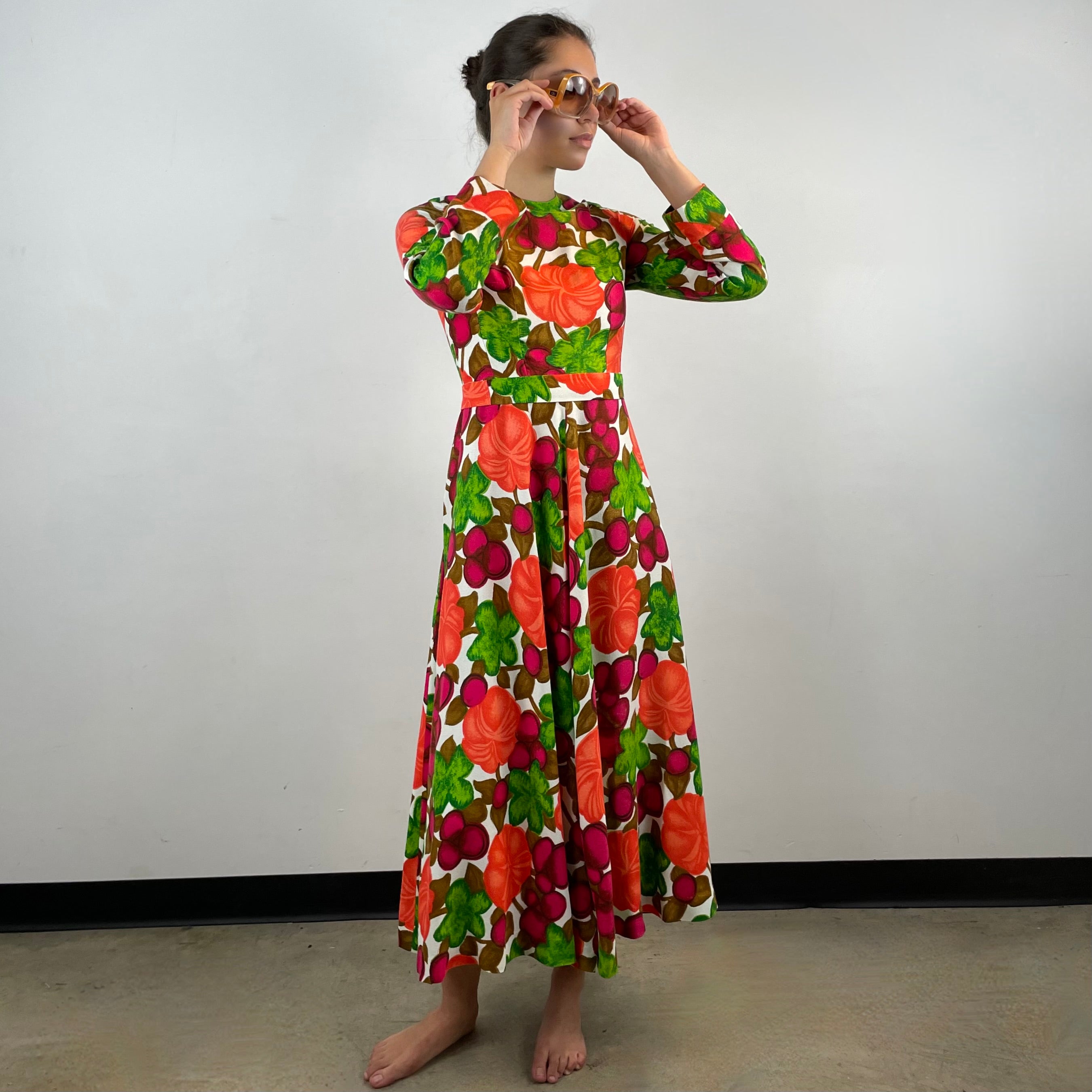 Vintage 1970s handmade long-sleeve dress in textured canvas-style fabric with bold artistic designs, fitted bodice, flared skirt and matching belt.