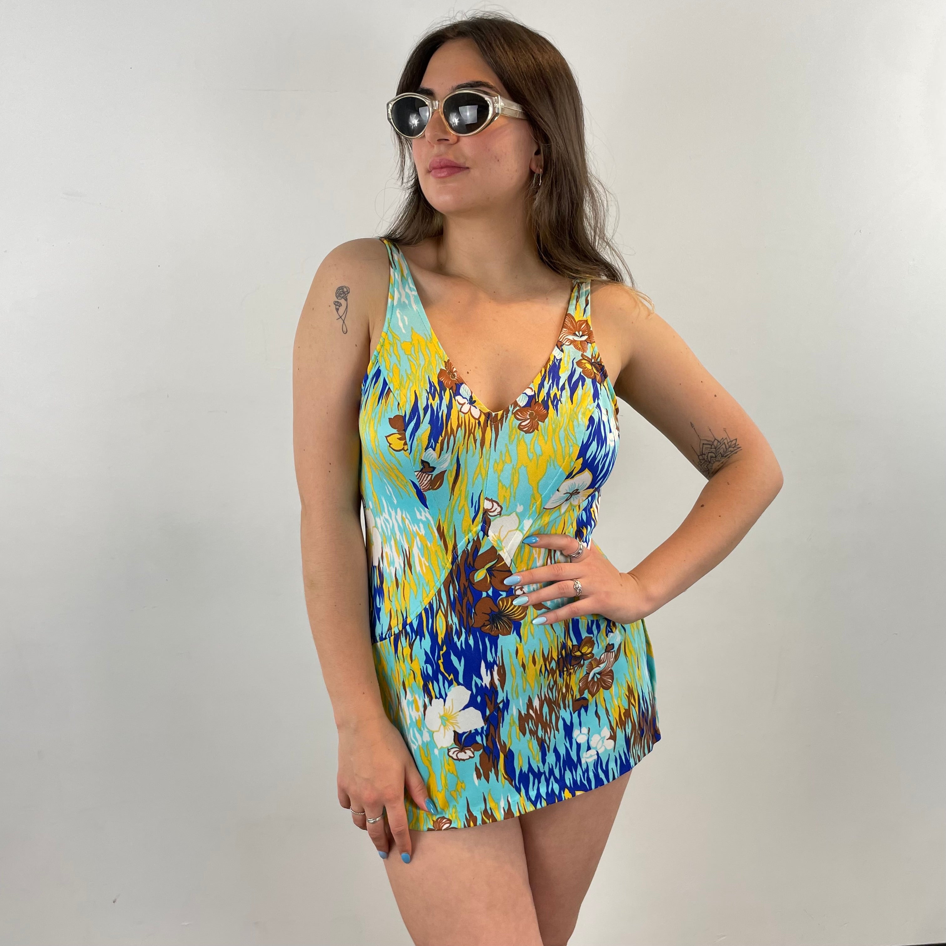 Boheme Vintage 1970s bold print skirted one-piece swimsuit with plunging V-neck, open back, and built-in mini skirt.
