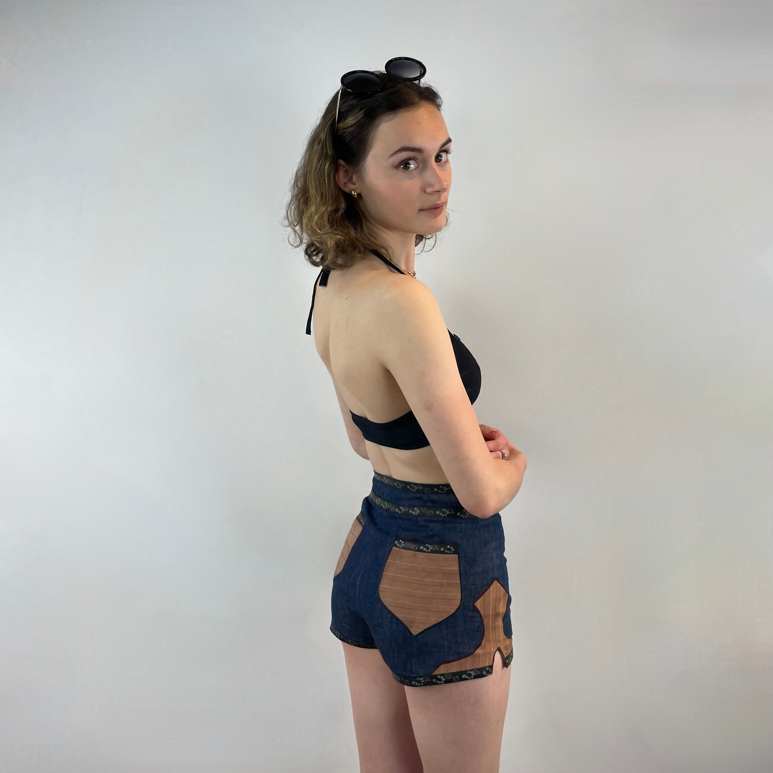 Boheme Vintage 1970s Roberto Cavalli denim and leather hot pants shorts with flower snap closures and leather appliqué details.