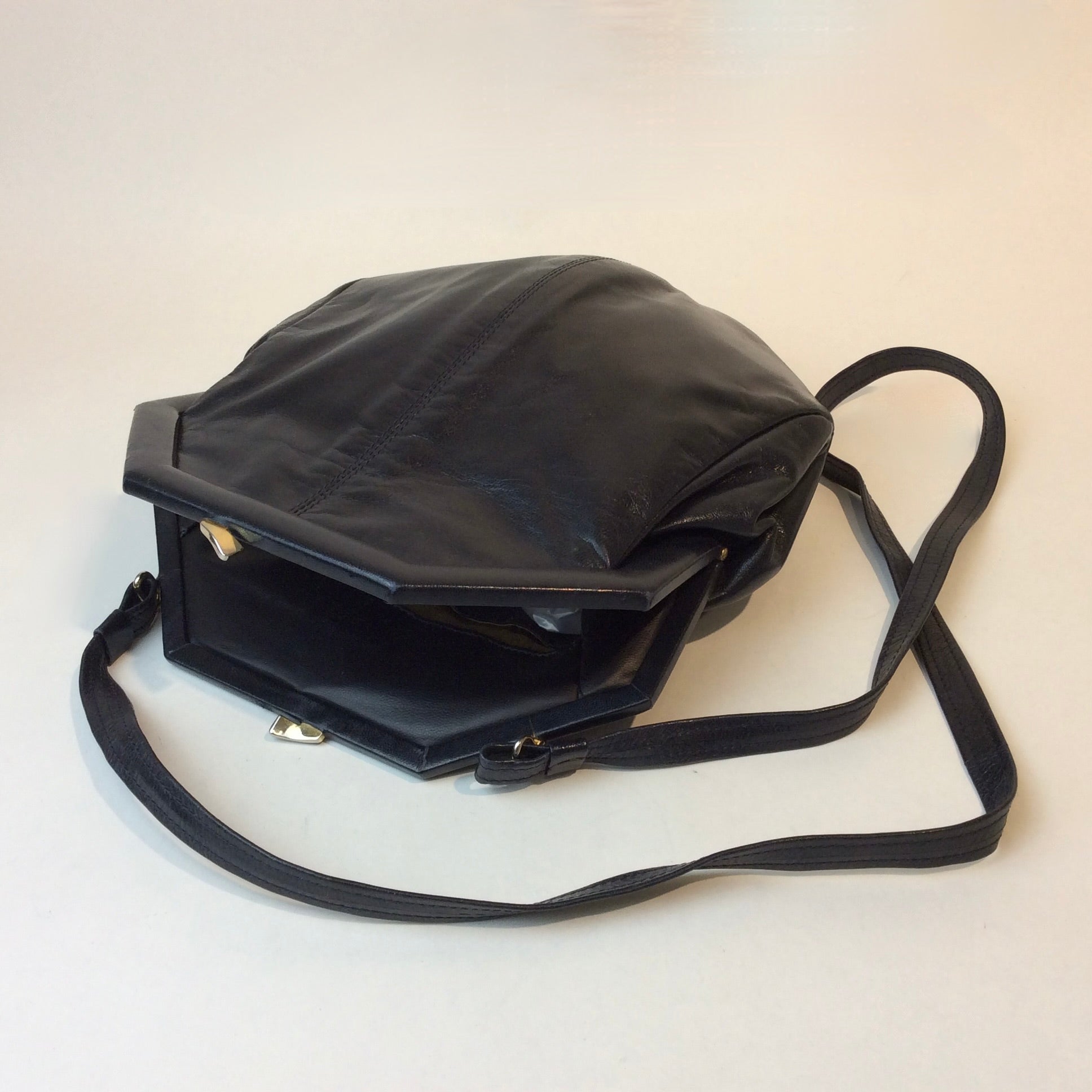 1980s Bruno Magli navy leather handbag with octagonal shape and gold push-lock closure, styled for shoulder or crossbody at Boheme Vintage in Montreal — bohemevintage.com