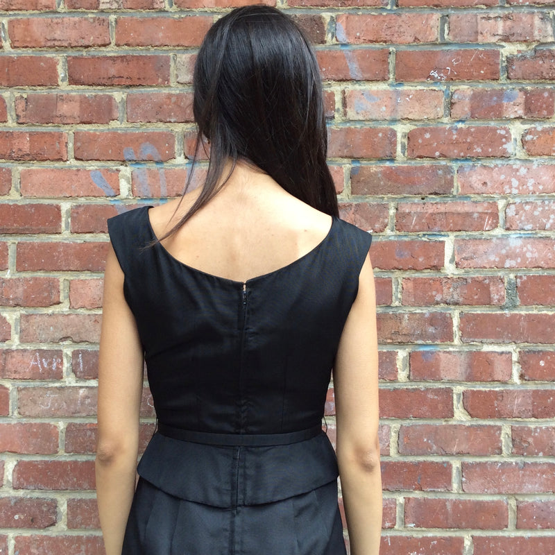 Close up back view of 1950s Black Dress With Peplum 
Size Extra-Small/Small 
Sold at bohemevintage.com
Montréal