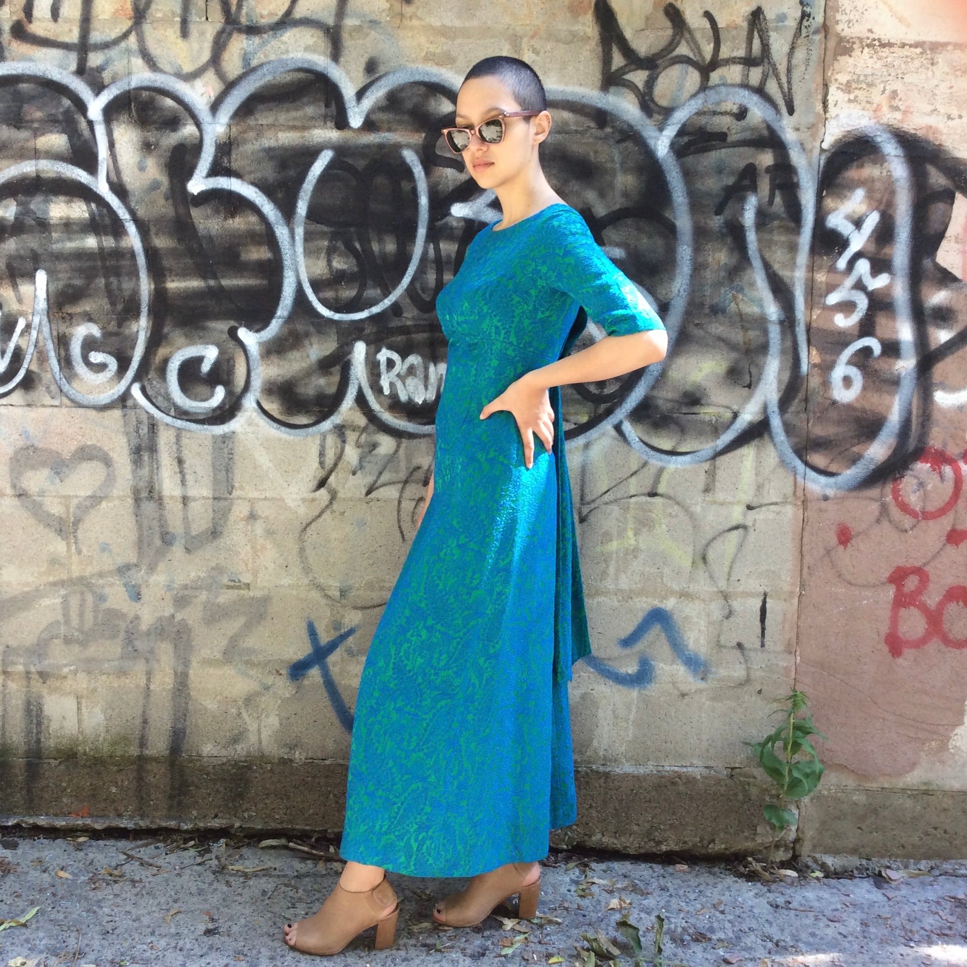 Side of Vintage 1960s blue and green brocade ankle-length evening dress with empire waist and low back detail, photographed in Montreal for Boheme Vintage – https://bohemevintage.com
 – Montreal vintage fashion boutique.