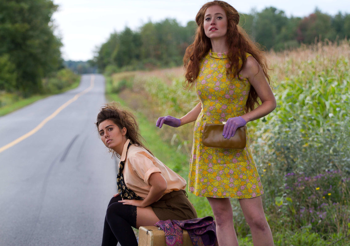 Two models are wearing vintage clothing and clothing and accessories from the 1950s, 1960s, 1970s. One of the girl is wearing a sleeveless floral print dress with 196hir0s lilac colour net gloves and holding a clutch purse, sold by Bohème Vintage
