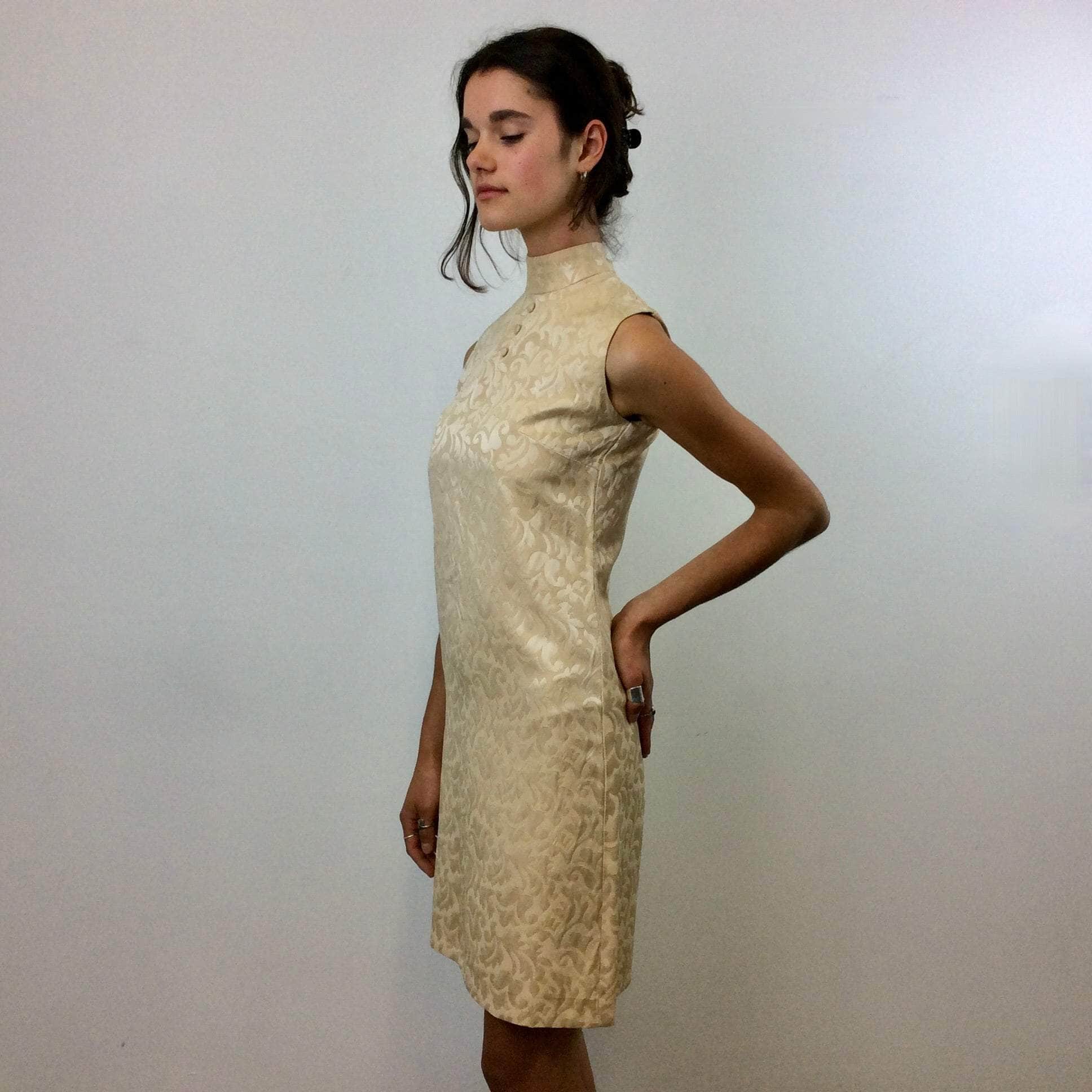 Side view of 1960s Beige Brocade Sleeveless Satin Shift Dress Small. Sold by Bohème Vintage. Montreal.