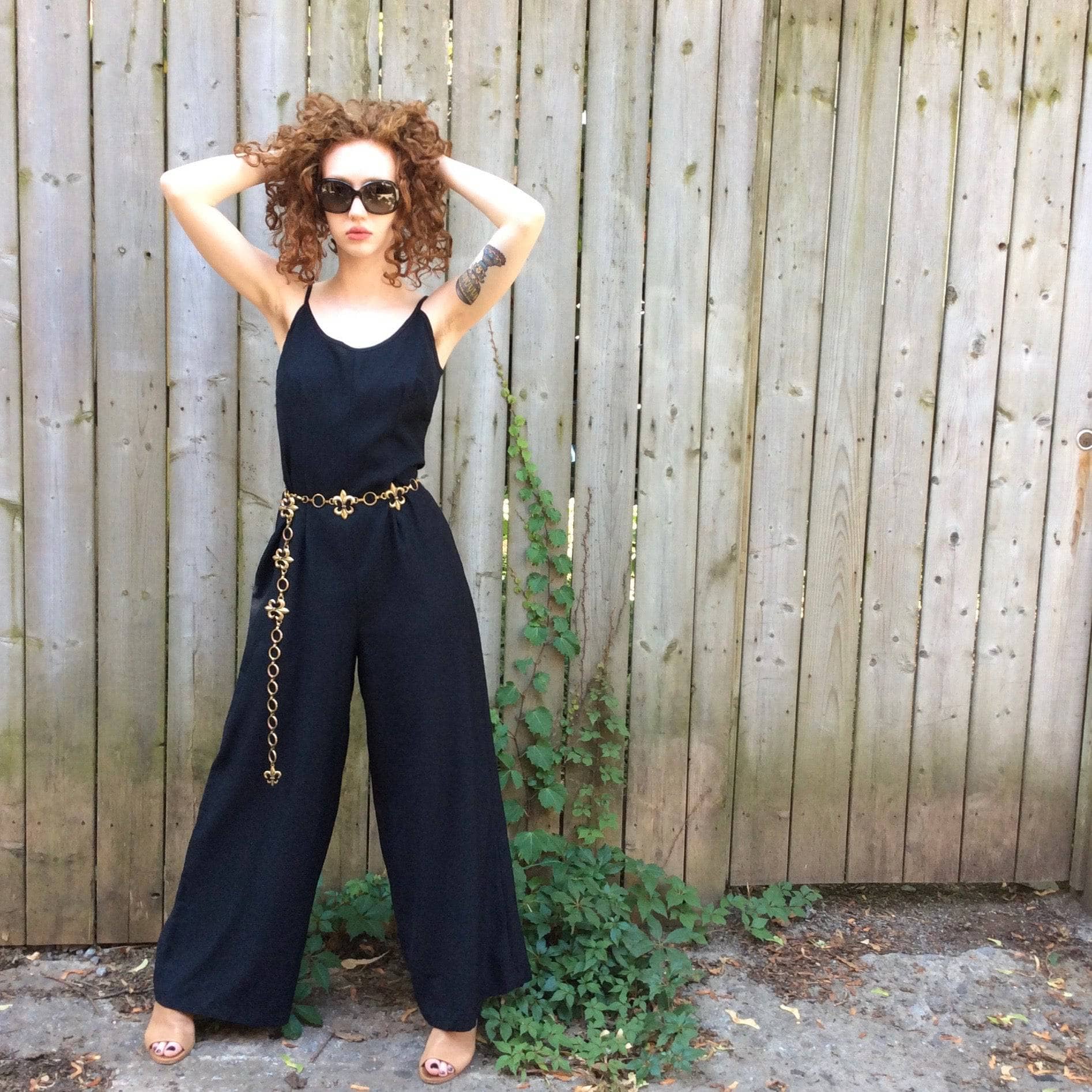 Front View of Boheme Vintage 1980s black wide-leg jumpsuit with fitted bodice, adjustable straps, and flowing silhouette.