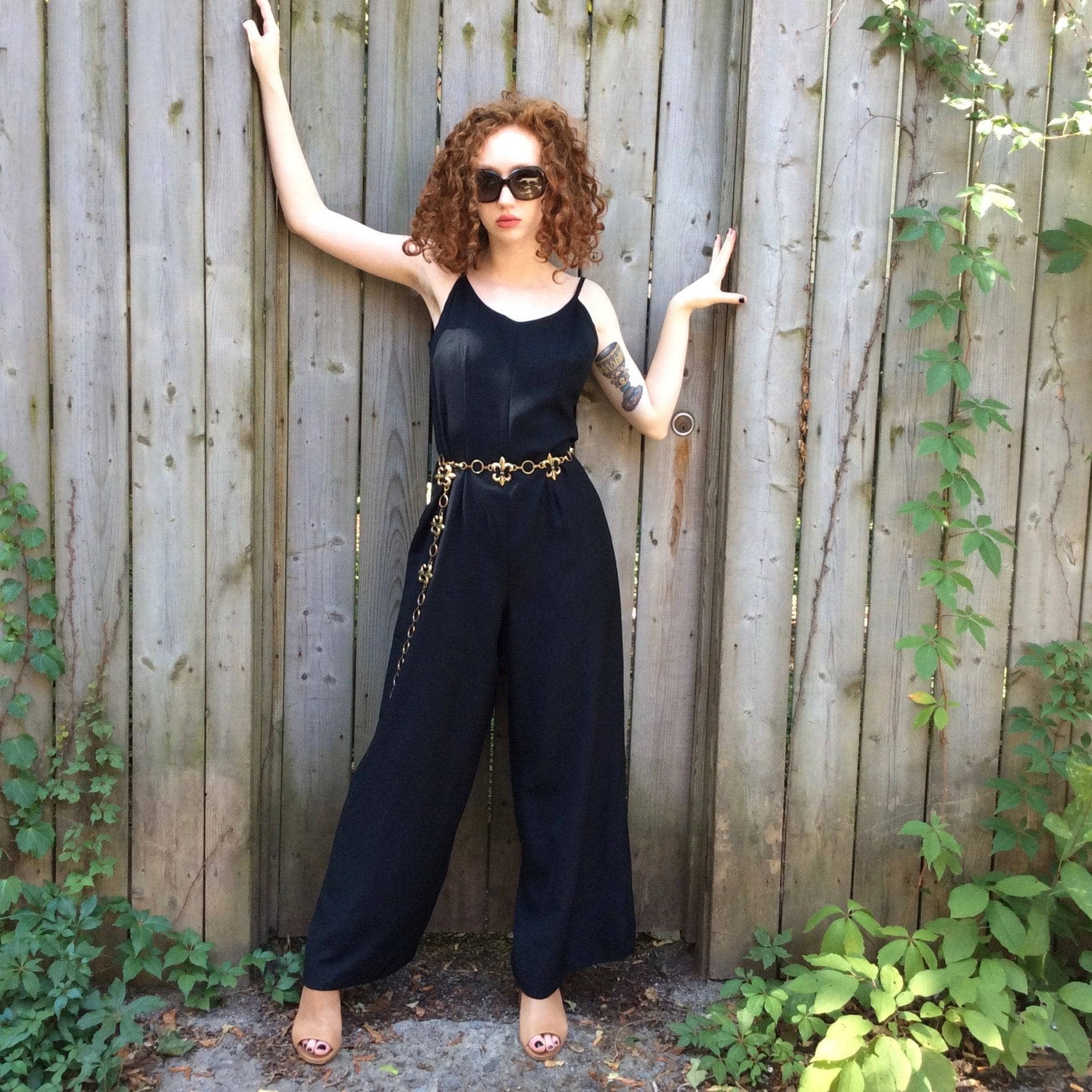 Front View of Boheme Vintage 1980s black wide-leg jumpsuit with fitted bodice, adjustable straps, and flowing silhouette.