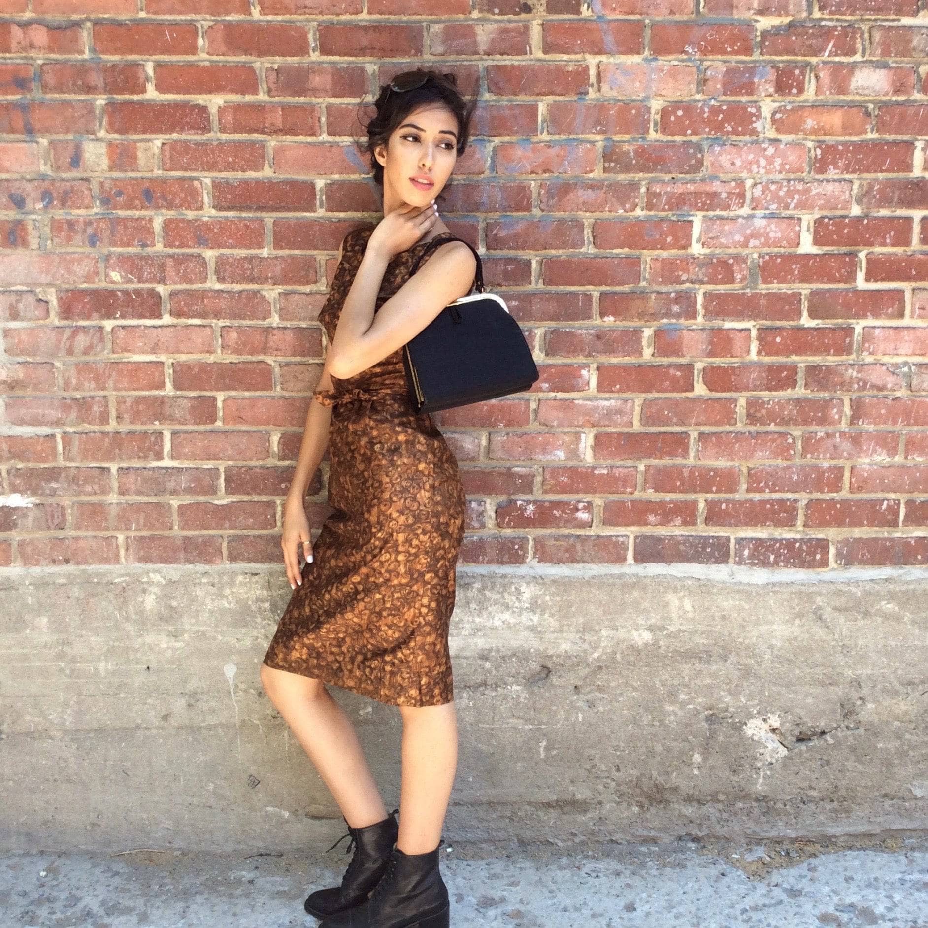  Side view of 1950s-60s Below the knee length Sleeveless Cotton Sheath Dress size Small with black handbag Sold by bohemevintage.com Montreal