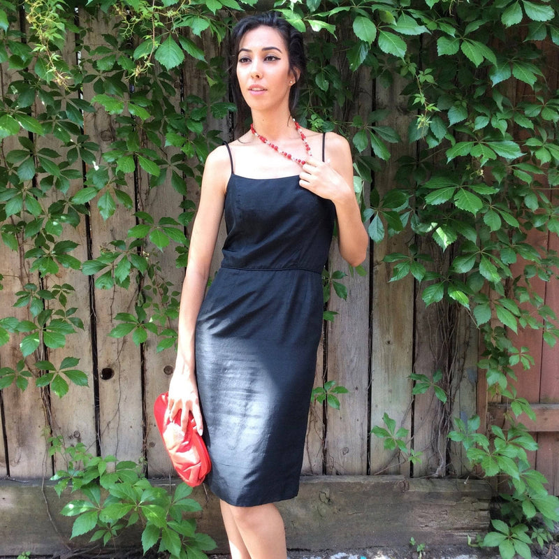 1950s Classic Black Silk Cocktail Dress Size Small Model is holding a 1980's Genuine Red Leather Clutch Handbag sold by bohemevintage.com Montreal 