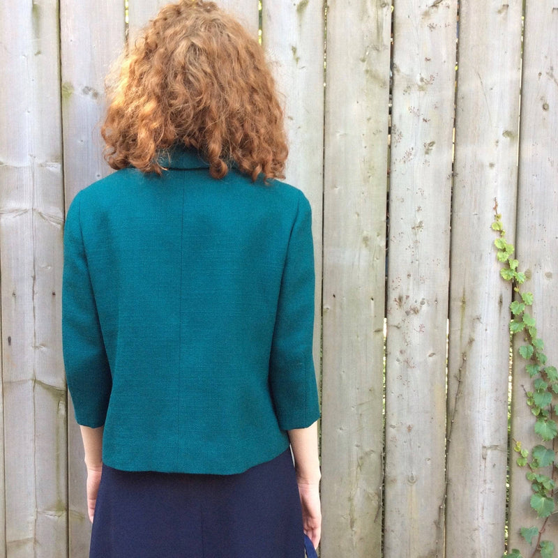 Back view of 1960s 3/4 Sleeve Teal Wool Blazer size small sold by bohemevintage.com Montréal