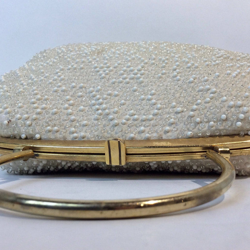 Close-Up view of Clasp of 1960s Cream Grandee Beaded Handbag with Brass Handle. Sold by bohemevintage.com Montréal