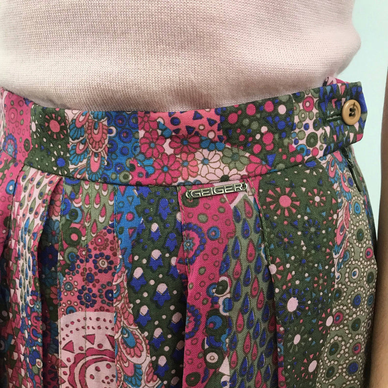 Close-up view of waistband and metal brand tag of 1990s Geiger Midi Length Foulard Print Pleated Midi Skirt Size small, sold by Bohemevintage.com