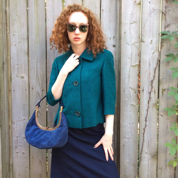 1950s Blue Suede Crescent Handbag Model is wearing Teal Wool Blazer Both Sold by bohemevintage.com Montréal
